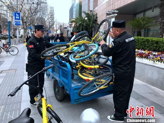 上海市中心一街道将违停车辆“请进白线” 共享单车居多