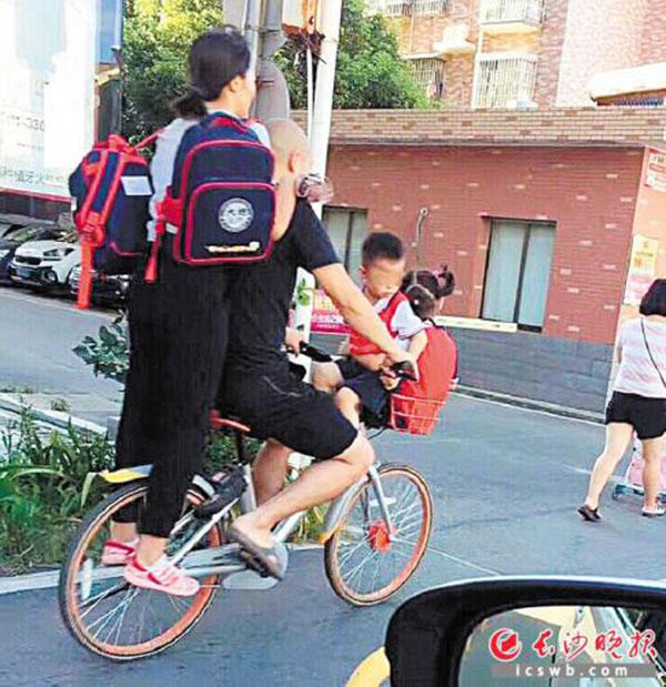 共享单车载4人上路:后面站1个把手坐1个篮子装1个