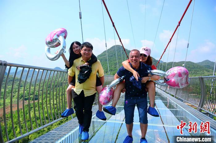 游客在清远连州擎天玻璃桥参与背老婆比赛 曾令华 摄